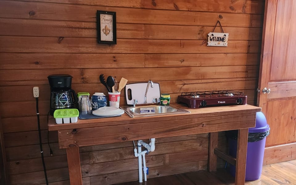 Our cozy cabin features a charming. Has stove, plates, glasses and cups. Coffe pot, most common kitchen utensils