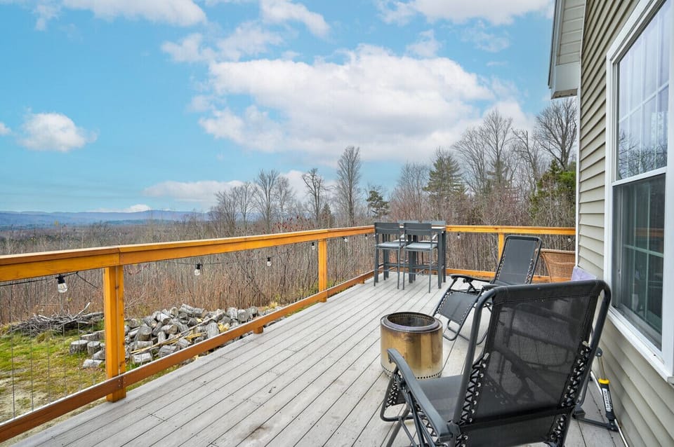 Relax on this beautiful deck with expansive views, cozy seating, a fire pit, and a dining area—perfect for taking in peaceful mountain scenery and unforgettable sunsets.