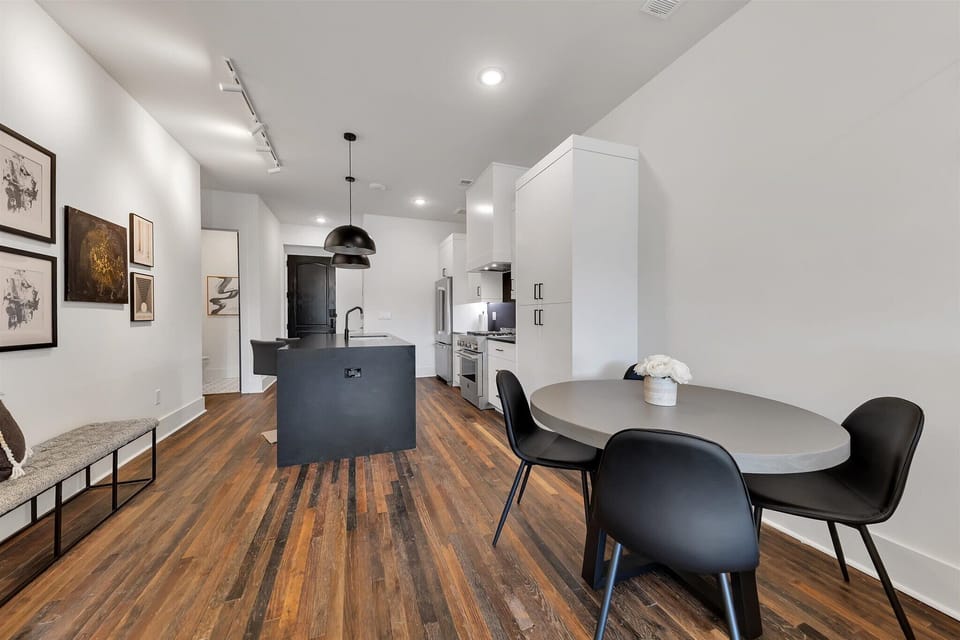 Open-concept kitchen & dining area w/ wood floors & modern finishes