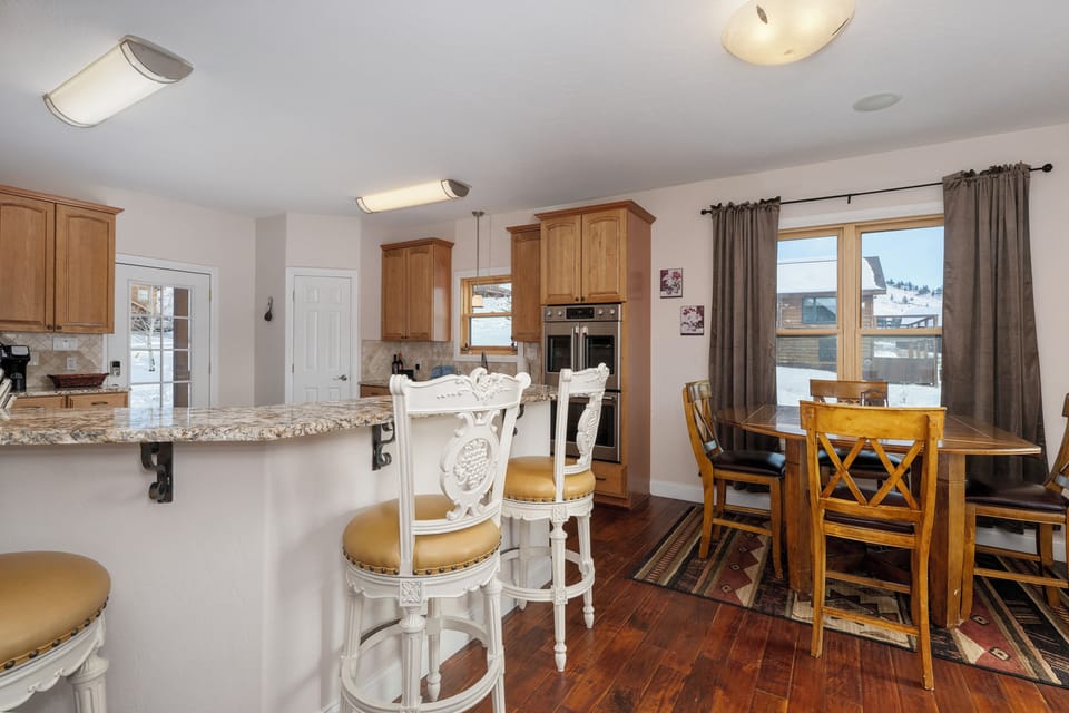Breakfast table with seating for 4, bar offers seating for 3.