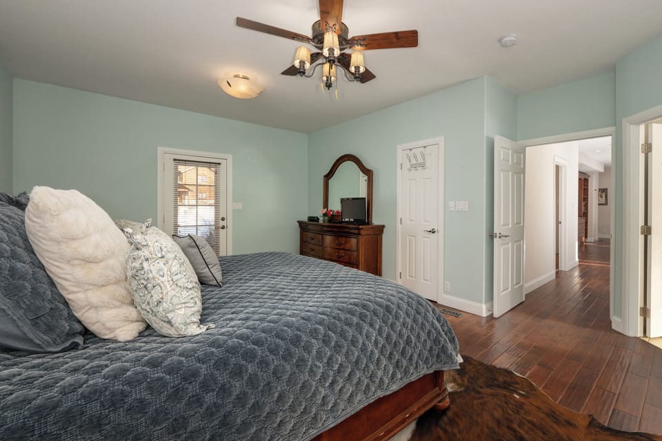Main level master suite with king bed, front and back deck access, and TV