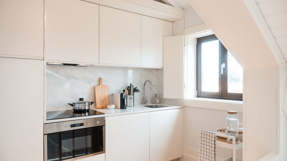 Prepare meals with ease in this stylish kitchen featuring sleek cabinetry, marble backsplash, and all the essentials for a comfortable stay.
#ModernKitchen #PortoAirbnb #HomeAwayFromHome
