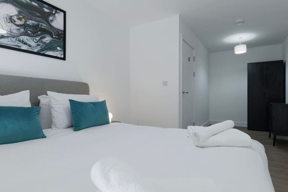 Fresh white bedding, teal cushions, and a good night`s sleep.