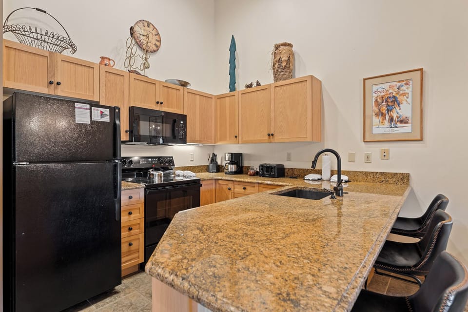 Your fully equipped kitchen awaits with granite counters, modern appliances, and a breakfast bar perfect for morning coffee.