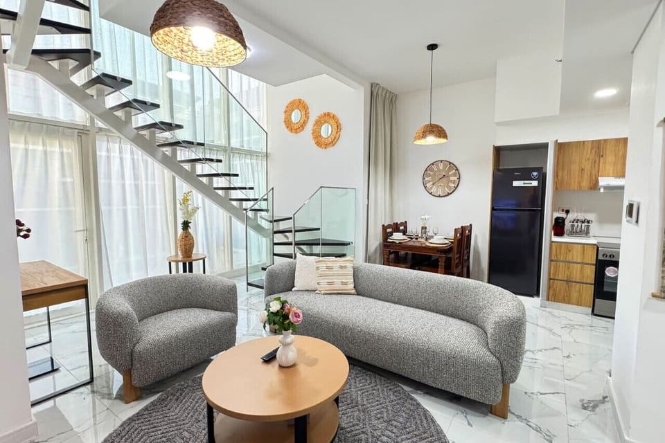 This open, airy living room invites you to relax in style. Enjoy cozy evenings with ambient lighting, a grand fireplace, and high-end touches that bring a modern twist to luxury.
