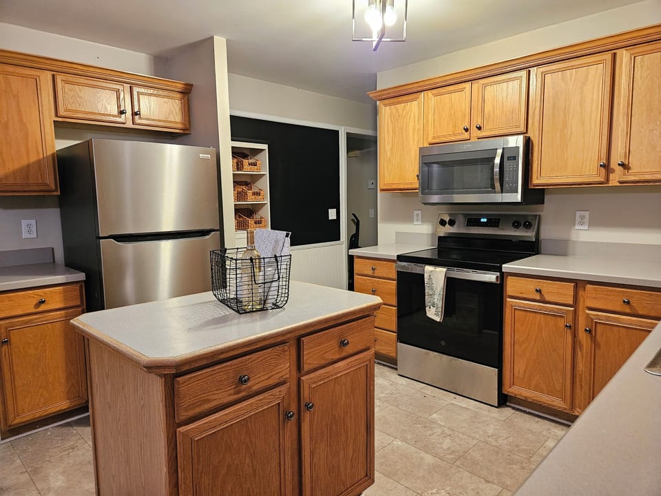 Kitchen is complete with a refrigerator, range, microwave and dishwasher
