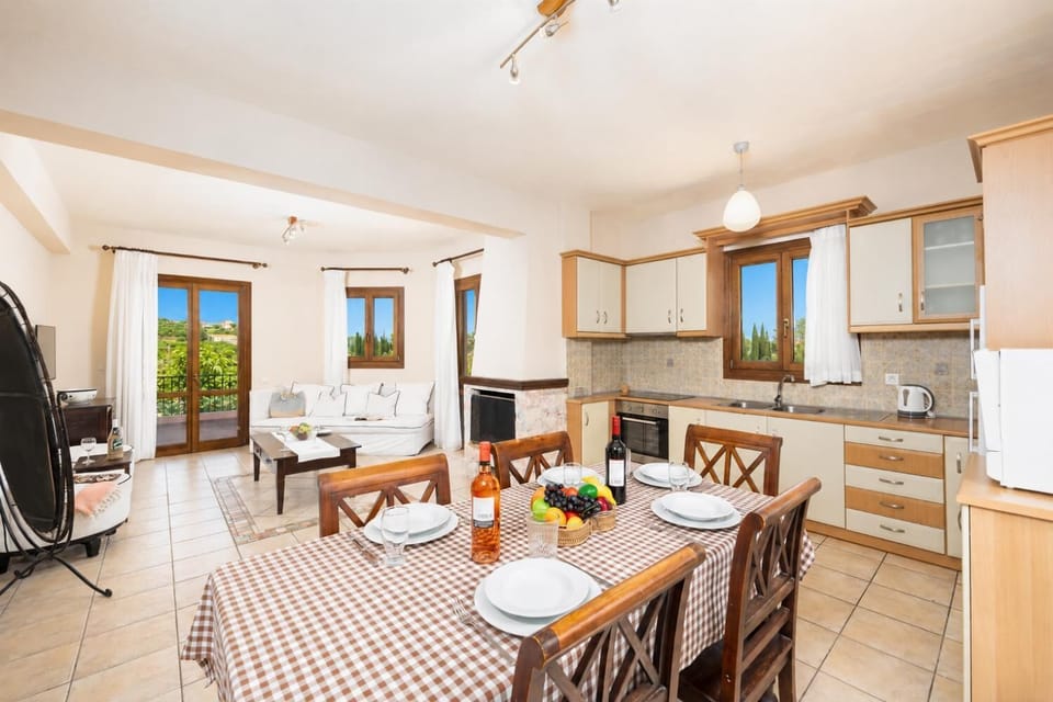Open-plan living room with sofa, dining area, kitchen, ornamental fireplace, A/C, WiFi internet, and satellite TV