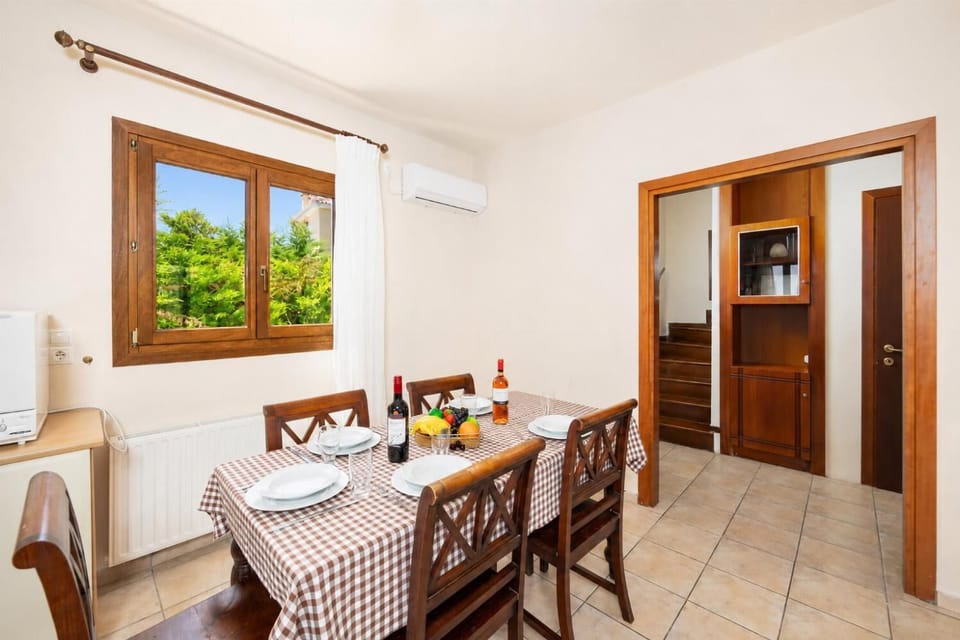 Open-plan living room with sofa, dining area, kitchen, ornamental fireplace, A/C, WiFi internet, and satellite TV