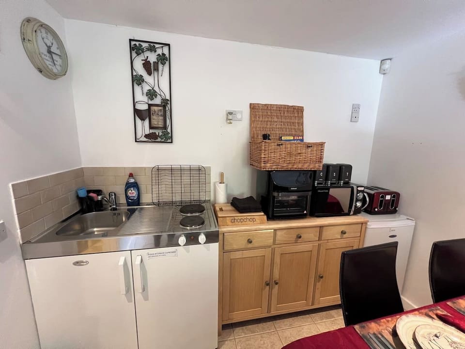 kitchen with air fryer, 2 ring hob, microwave, fridge, kettle, toaster, sink, bin cupboard, food storage area, much loved welcome basket & more.  

Full kitchen being fitted winter 2025 with dishwasher, washing machine, oven & wall units.