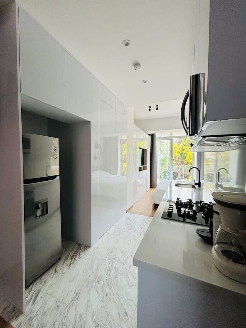 Designed for extended stays, this sleek kitchen boasts a full-sized fridge for all your needs, paired with abundant closet space to keep your belongings perfectly organized. A blend of functionality and style awaits!