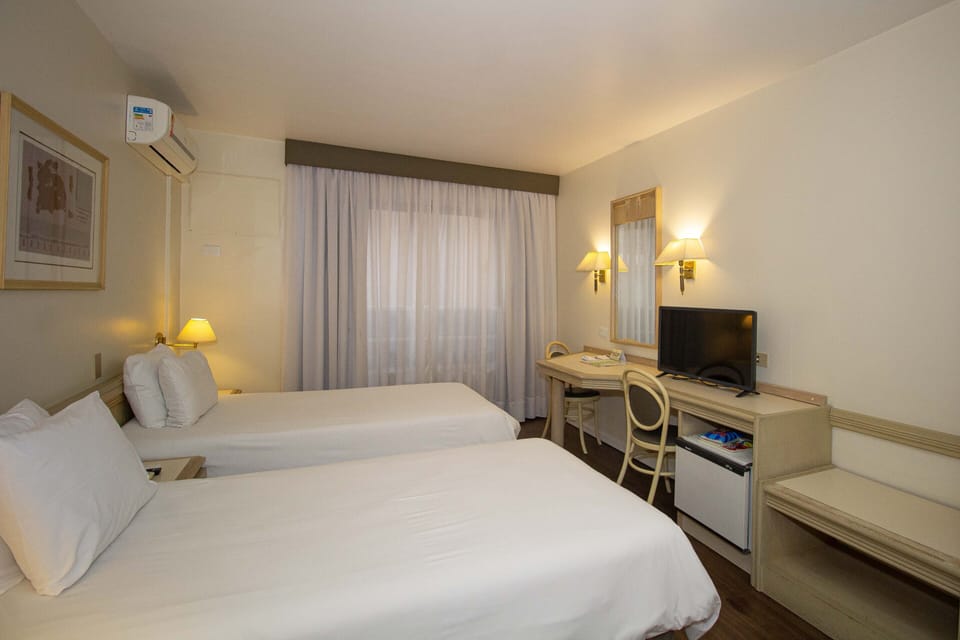 Apartamento Luxo Twin | Minibar, desk, blackout drapes, soundproofing