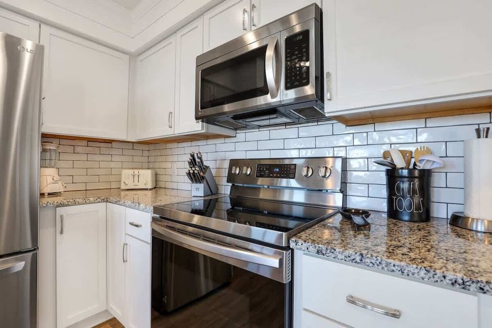 The granite countertops provide ample prep space above a glass-top stove.