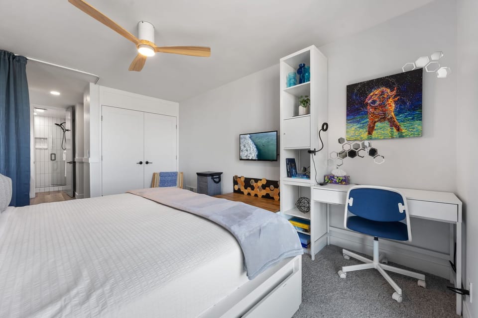 A workspace featuring a desk and desk chair is provided in the bedroom for guests requiring an area to work with a ring light