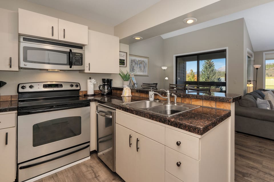 Your modern kitchen features granite countertops, stainless appliances, and a pass-through design perfect for entertaining while enjoying mountain views.