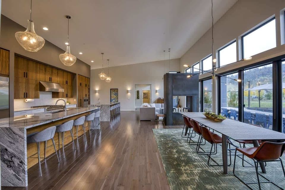 The open-concept great room combines a chef’s kitchen, dining area, and gathering space under soaring ceilings.