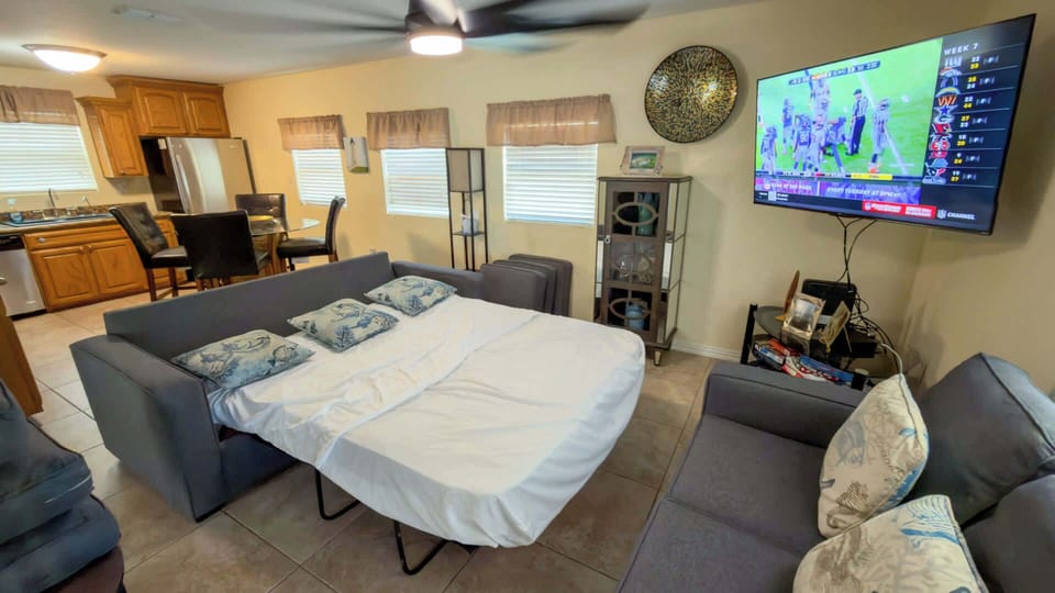 Versatile Sleeper Sofa Media Den
Pull-out sofa bed + 55" TV for movie nights or extra guests! Open to kitchen, fan-cooled in sunny yellow tones. Family-friendly at 113 E Pompano St—beach, harbor & SpaceX nearby. 