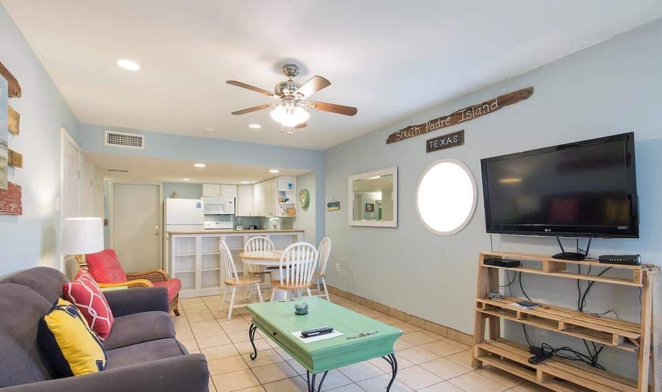 A cozy, colorful gathering space with an easy coastal warmth, where relaxed seating and soft, lived‑in touches create a welcoming flow. It’s a bright, comfortable spot that naturally invites conversation, downtime, and simple moments together.