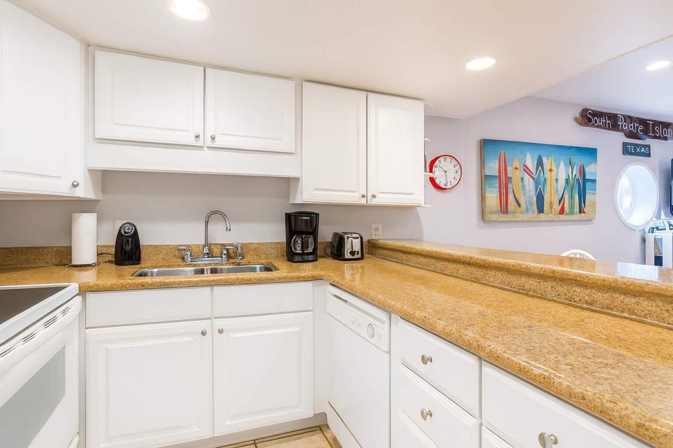 Bright Coastal Kitchen Near South Padre Beach
Enjoy clean, well-lit kitchen featuring white cabinetry, granite countertops, and modern appliances. Surfboard art & South Padre Island décor add coastal charm—perfect for relaxing mornings with coffee.
