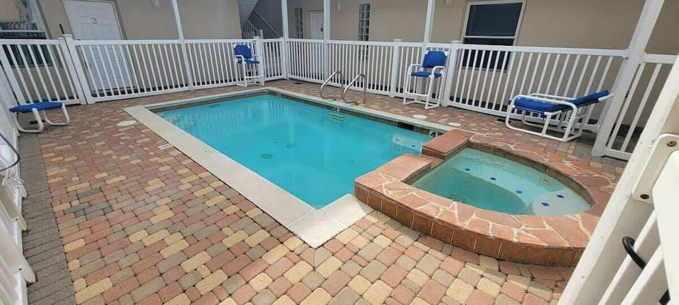 Relax in style at this inviting poolside escape, featuring a sparkling pool, soothing tub, and comfortable lounge seating—perfect for families, couples, or groups seeking leisure, comfort, and memorable coastal stays.