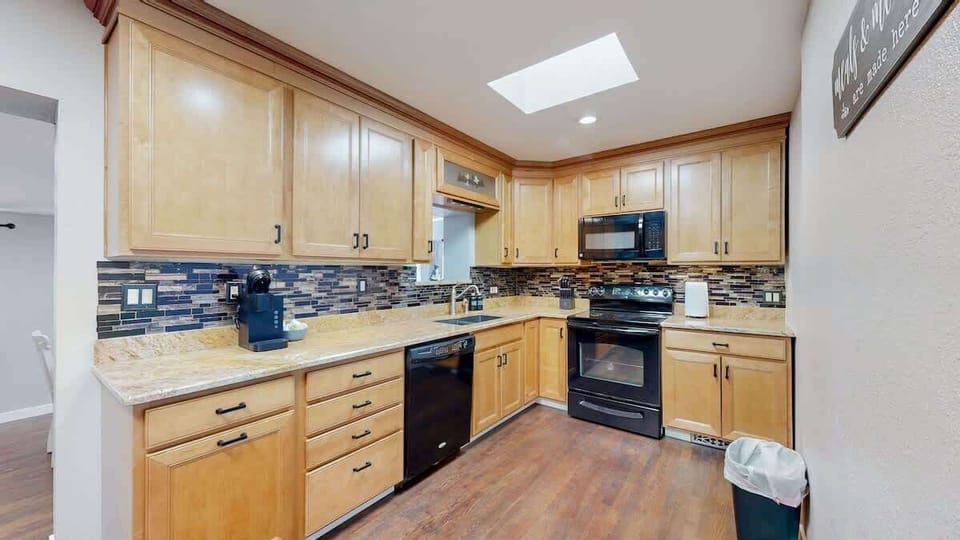 The kitchen is equipped with a variety of appliances, including everything you need for easy meal preparation, from a stove and refrigerator to a microwave and coffee maker.