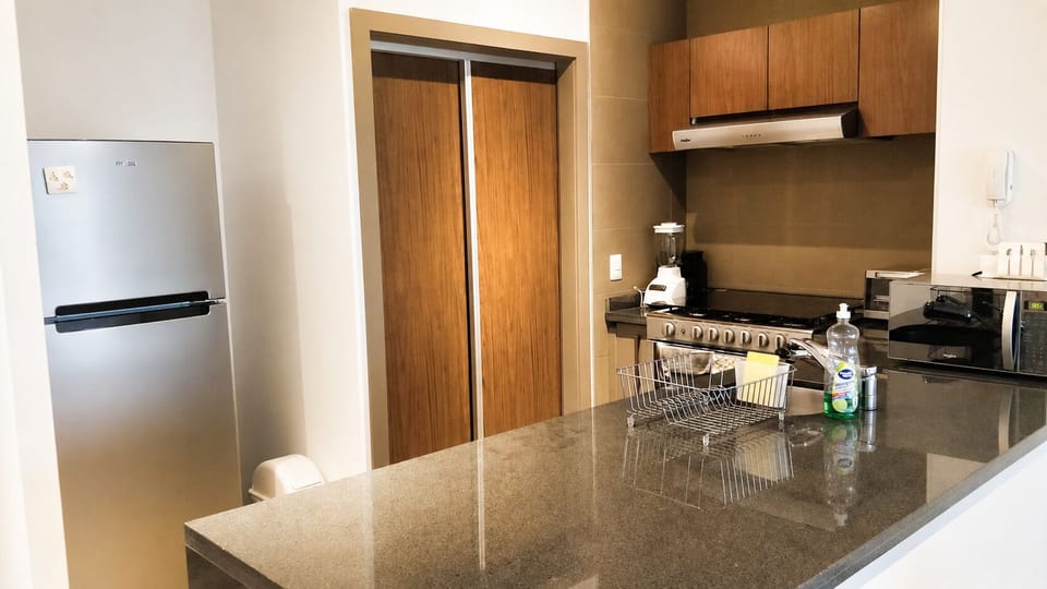 Cook with ease in a fully equipped kitchen featuring modern appliances, cookware, dinnerware, and a dishwasher.