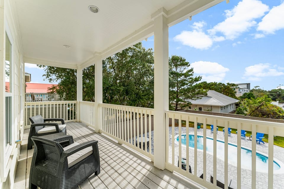 The master suite opens to a private balcony overlooking the beautiful backyard and pool, which is also accessible from another bedroom on the second floor, offering a shared space with breathtaking views.