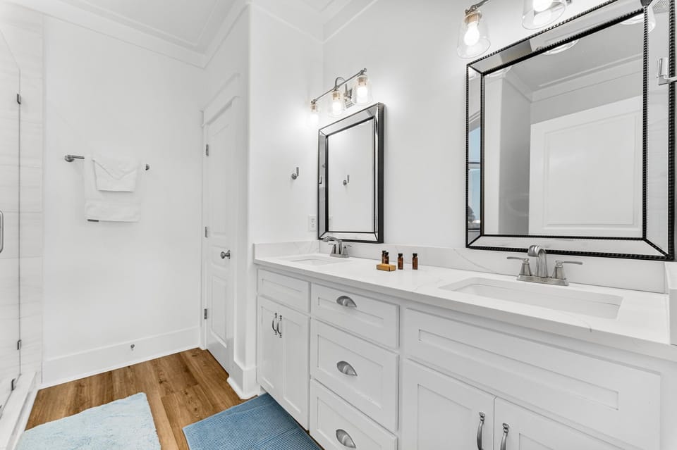 The en-suite master bathroom boasts a beautiful double vanity with sleek quartz countertops, offering a stylish and functional space.
