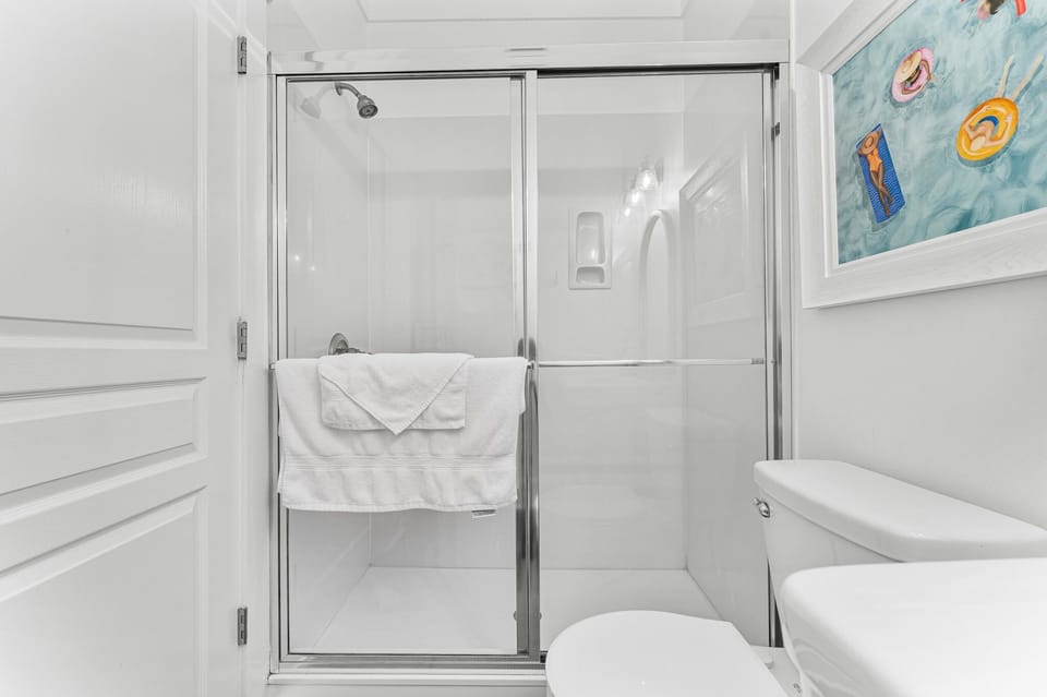 The downstairs bathroom features a full walk-in shower and a toilet, providing both comfort and easy accessibility for guests.