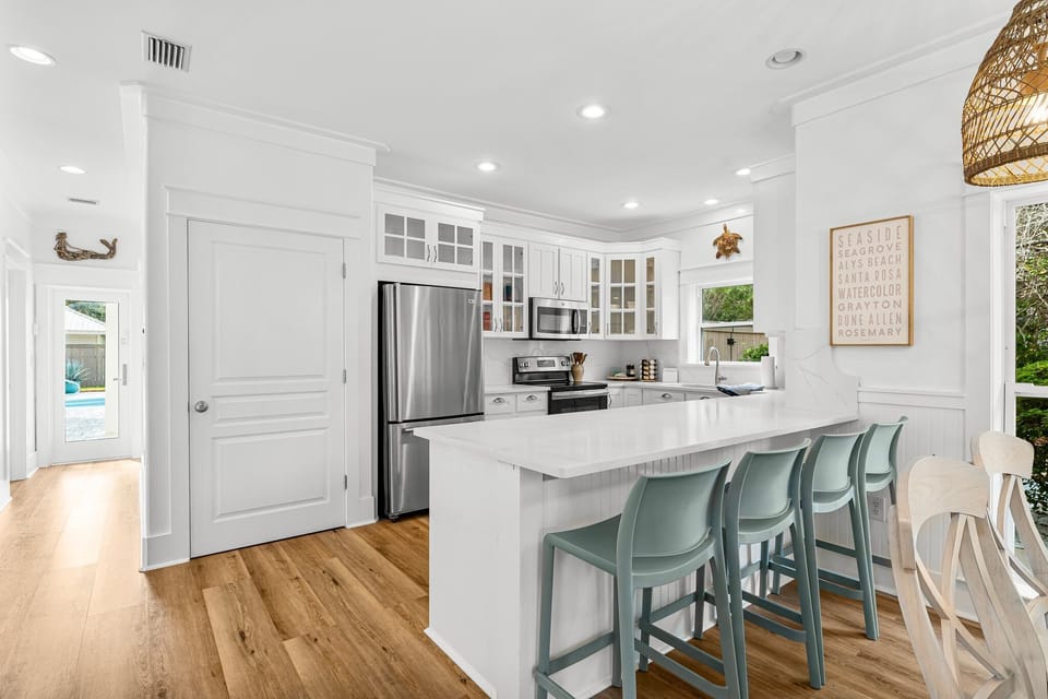 The kitchen is beautifully designed with four additional barstools at the counter, providing extra seating and a casual space for both dining and socializing. 