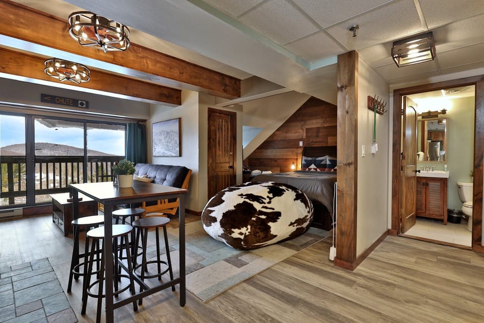 The dining spot is close to the balcony, with the sleeping nook and bathroom nearby.