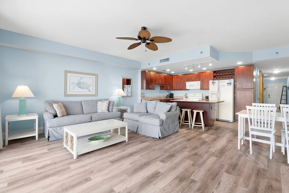 Open-concept living area with coastal-inspired decor and a fully equipped kitchen.