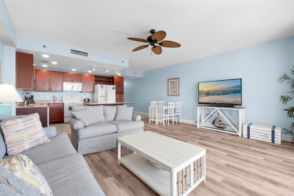 Open-concept living area with coastal-inspired decor and a fully equipped kitchen.