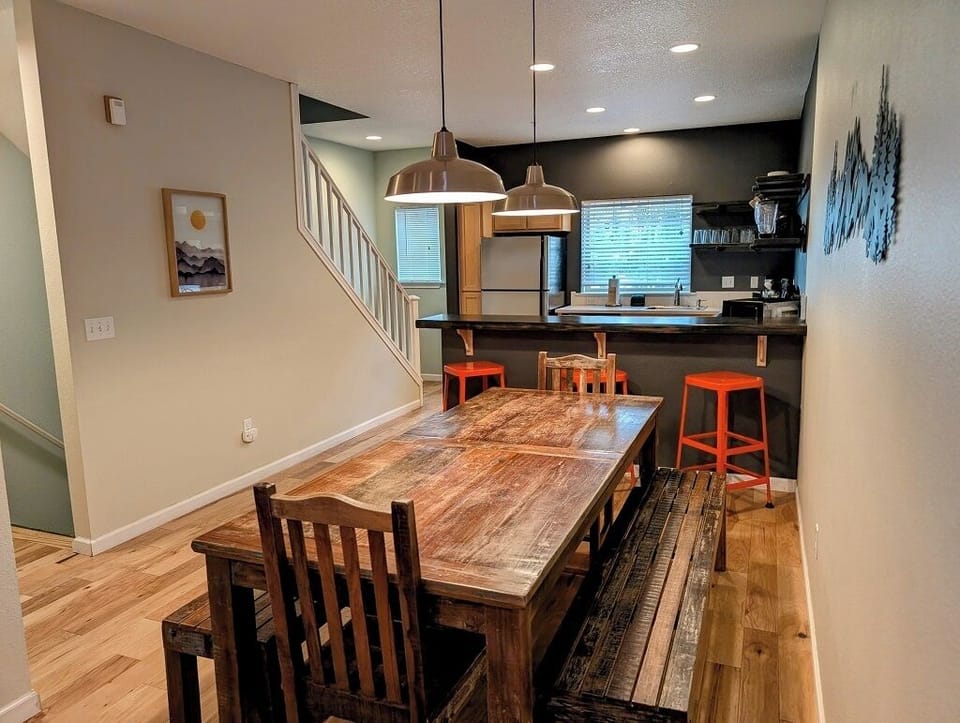 Large family-style wood dining table with two benches and two chairs.