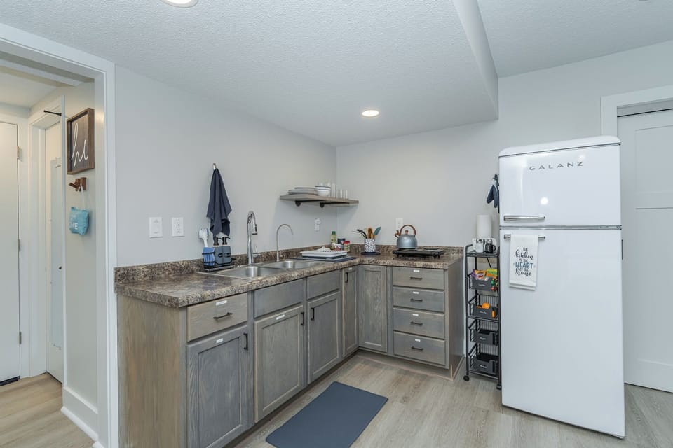 kitchen with dishes, pots/pans, prep tools, two burners, purified drinking water
