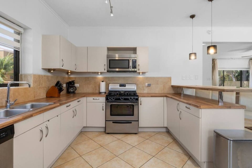 Clean, contemporary kitchen with stainless steel appliances, wooden countertops, and ample storage space.