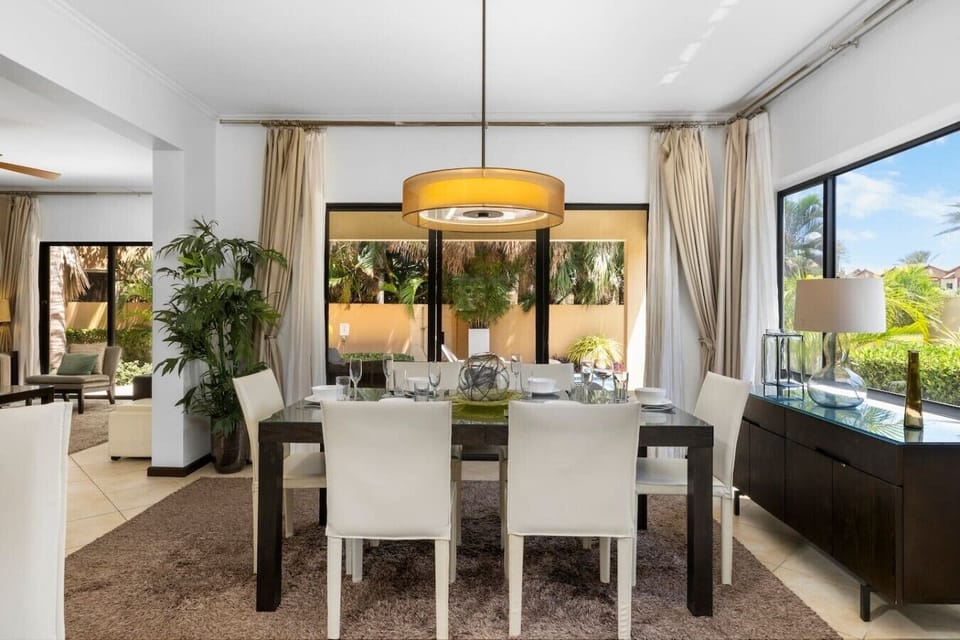 Elegant dining space with modern chairs, a stylish pendant light, and a scenic view of the outdoors