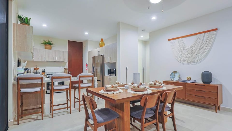 Dining area with bar stools and kitchen view.