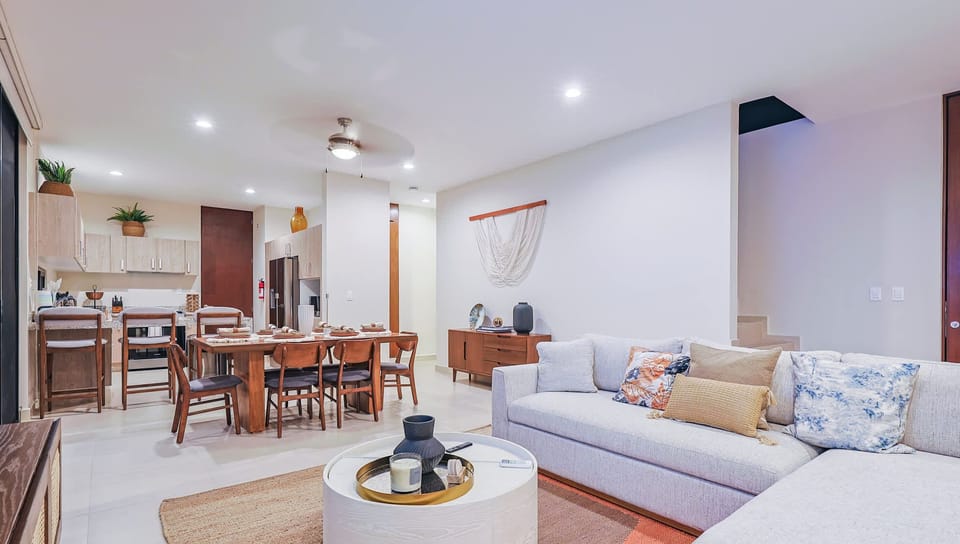 Open-concept living and dining area with a spacious sectional and fully equipped kitchen.