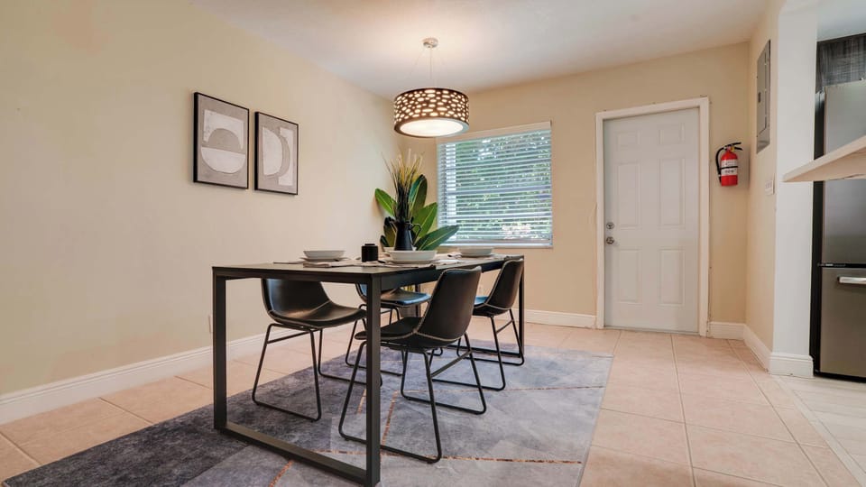 Enjoy meals in this stylish dining area with modern decor and natural light, perfect for intimate gatherings.