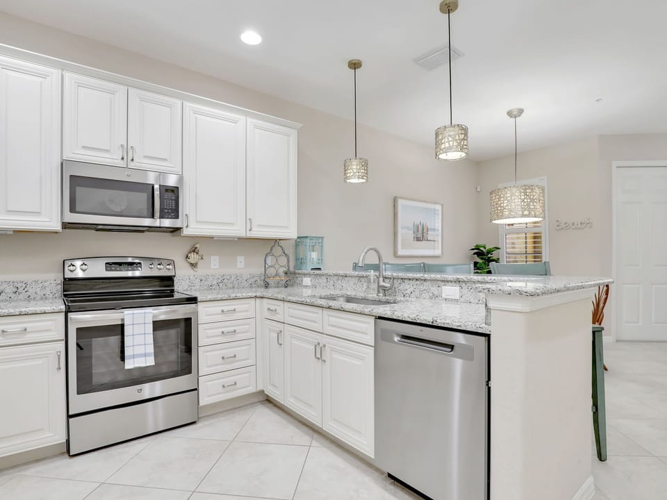 Modern kitchen with stainless steel appliances and granite countertops.