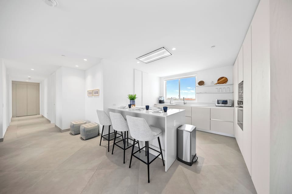 Step into this bright, modern kitchen where you'll find everything you need to prepare your favorite meals. Enjoy morning coffee at the stylish island, bathed in natural light from the window overlooking the city.