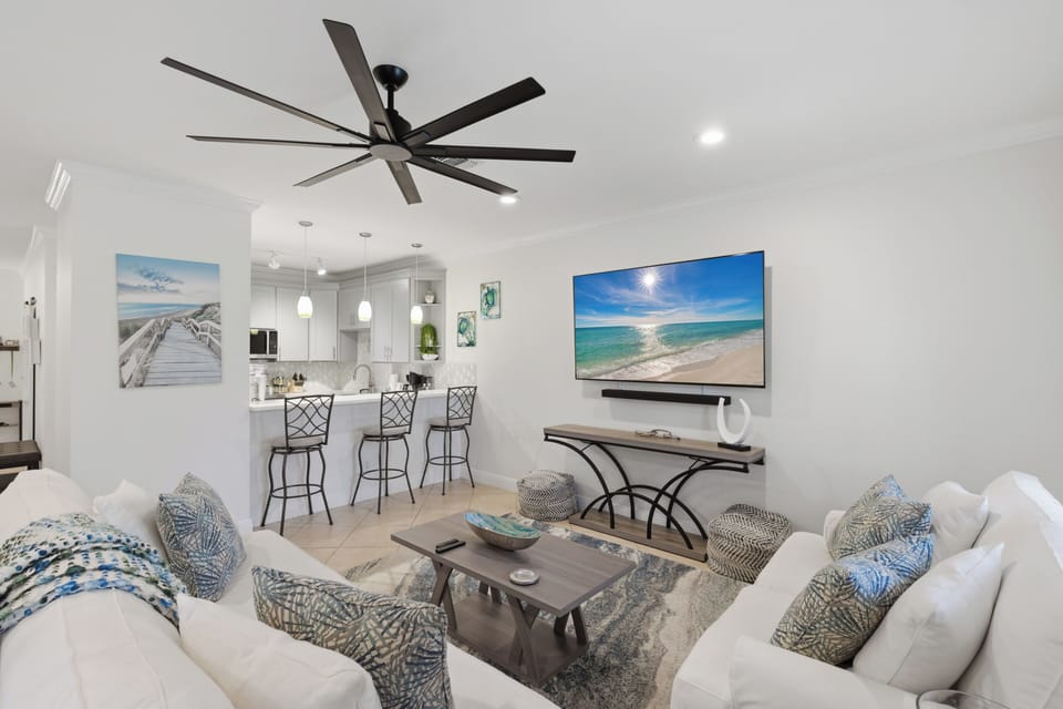 Relax in your bright, coastal-inspired living space with plush seating, modern entertainment, and an open kitchen perfect for vacation meals.