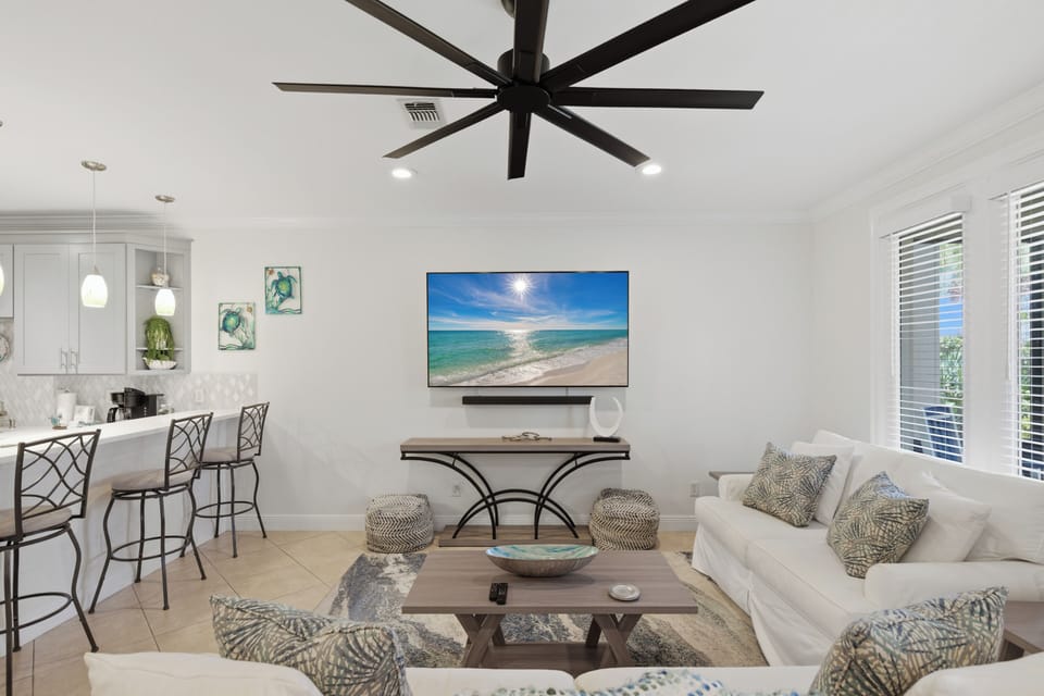 Unwind in your bright, modern living space with coastal decor, ceiling fan comfort, and open kitchen perfect for vacation moments.