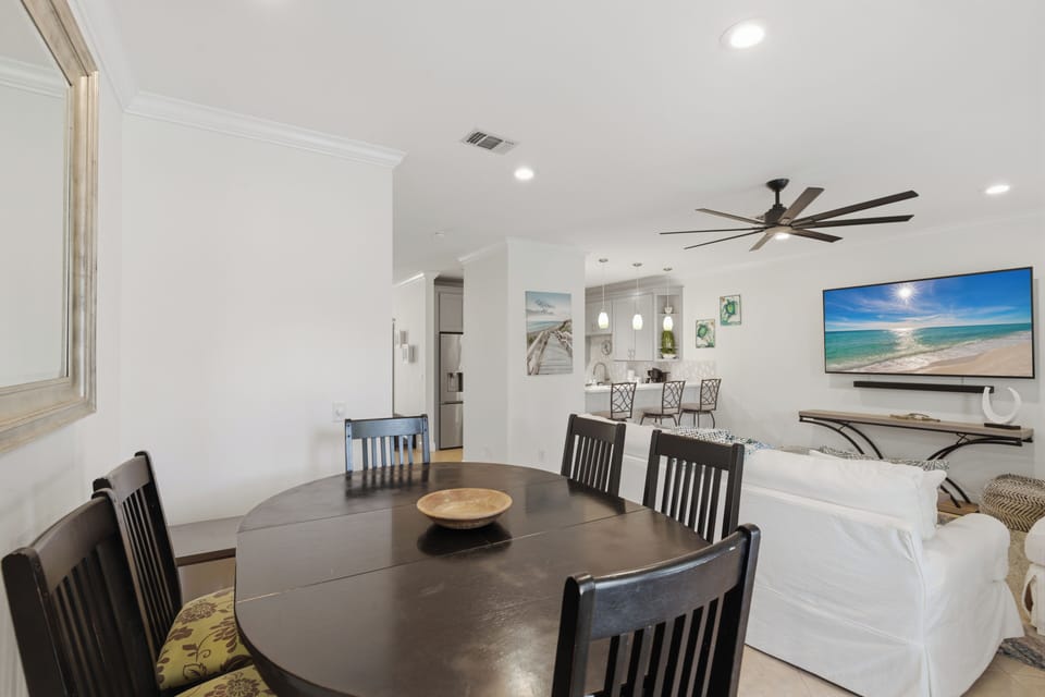 Gather around your spacious dining table while coastal artwork and a large TV create the perfect atmosphere for memorable meals together.