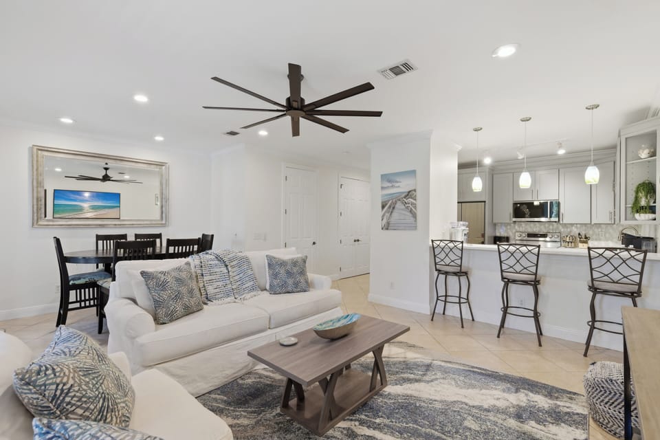 Your open-concept retreat combines coastal style with modern comfort, where plush seating and beachy artwork create the perfect gathering spot.
