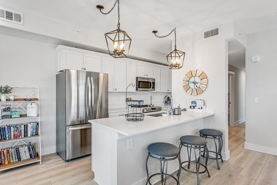 Bar seating for 3 in stocked kitchen with granite counter tops and stainless steel appliances