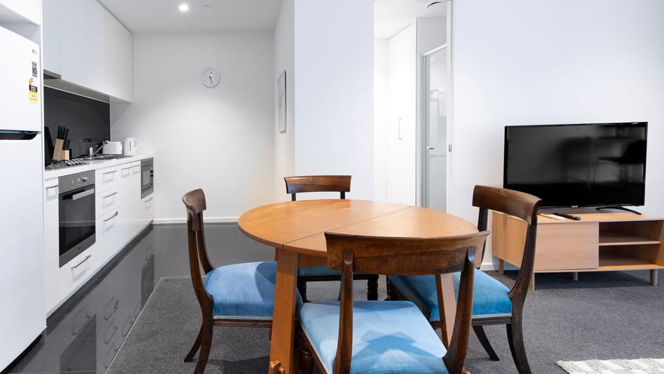 A cozy wooden dining set sits perfectly adjacent to a sleek, modern kitchen space.