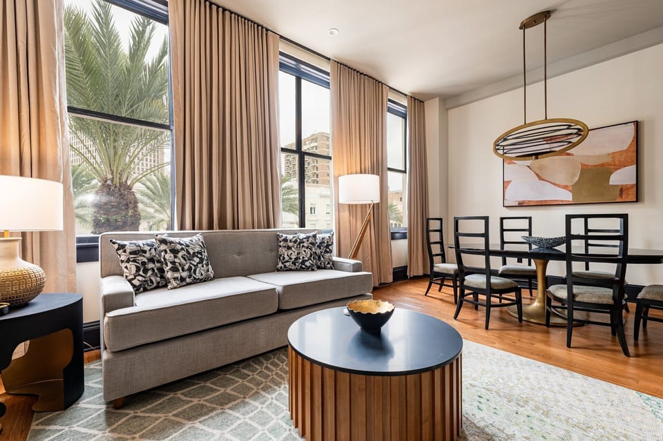 Elegant living space overlooking Canal Street, framed by tall windows that flood the room with light and offer a vibrant cityscape view.