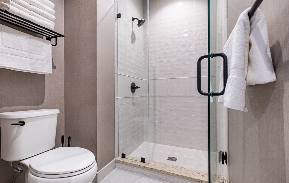 Bathroom 1 - Spacious walk-in shower with sleek glass doors and modern fixtures.