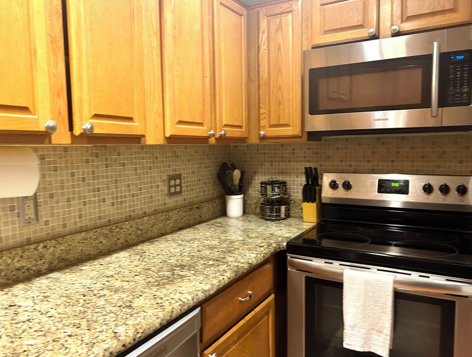Full kitchen with stove, microwave, dishwasher, refrigerator with ice-maker